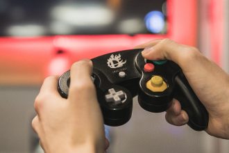Student holds a gaming device in the Student Center Game Room.