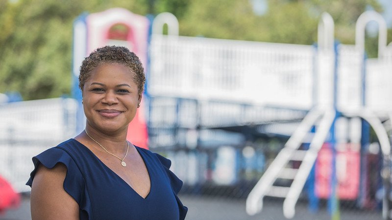 Erica Watson Brown stands outside in a playground.