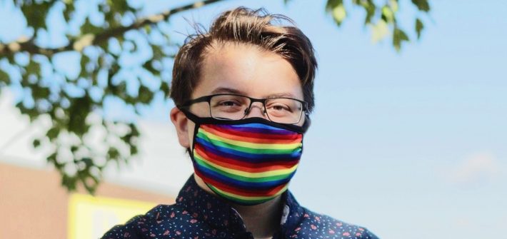 Emerson wears a rainbow mask outside.