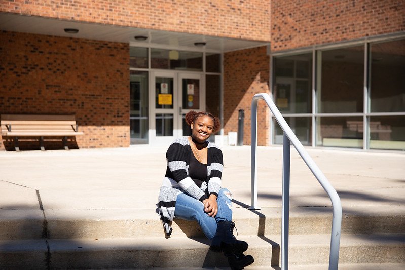 M'yonna sitting on the steps outside the Wellness Center.