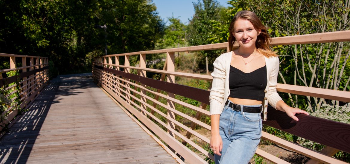 Angela stands on a bridge on campus.