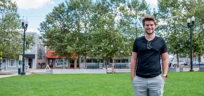 Dan stands in a field of grass.