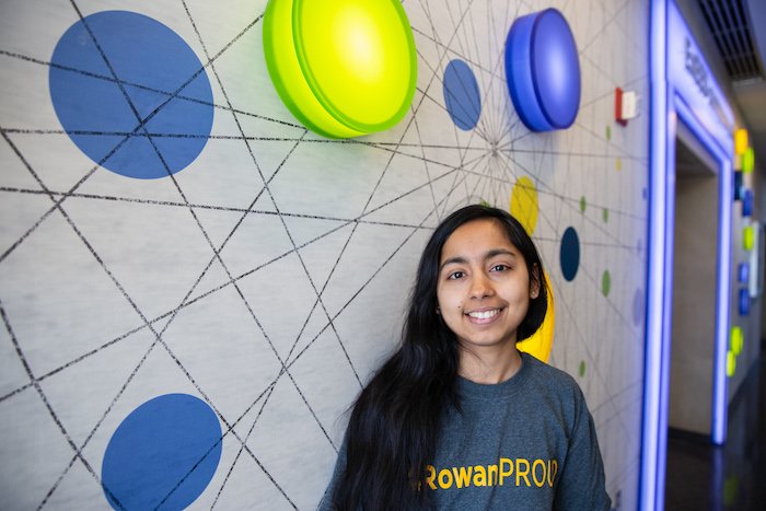 Gatha smiling for a picture while wearing a Rowan Proud shirt.