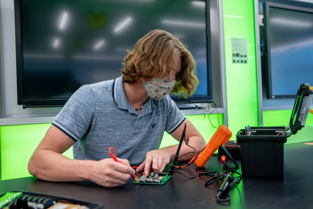 Nicholas Kreuz working on electronics in an engineering lab.