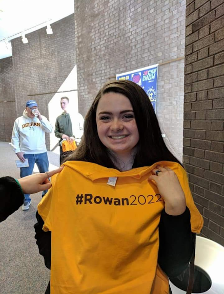 Courtney posing with a Rowan shirt inside the Wilson Hall building.
