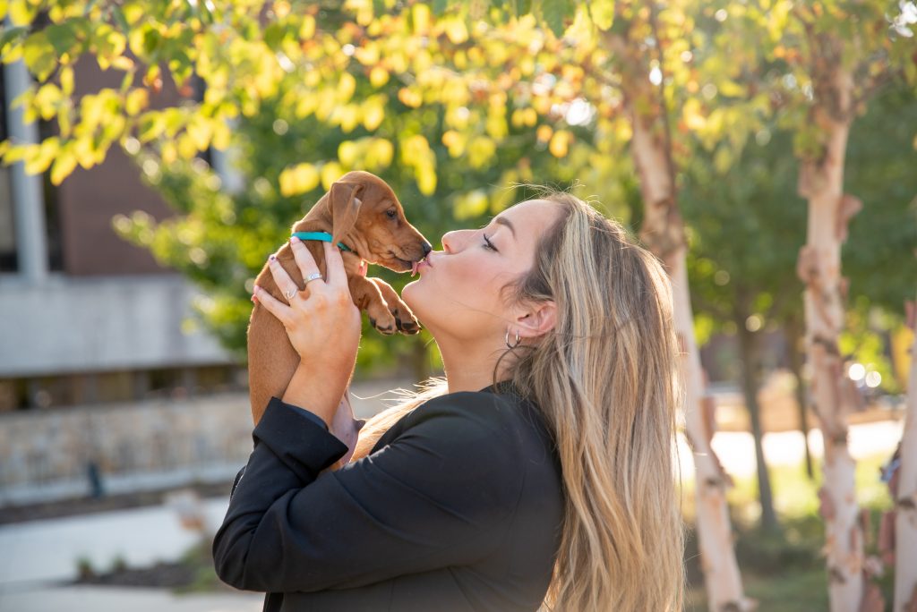 Slinky the dachshund giving his owner Sarah a kiss outside.