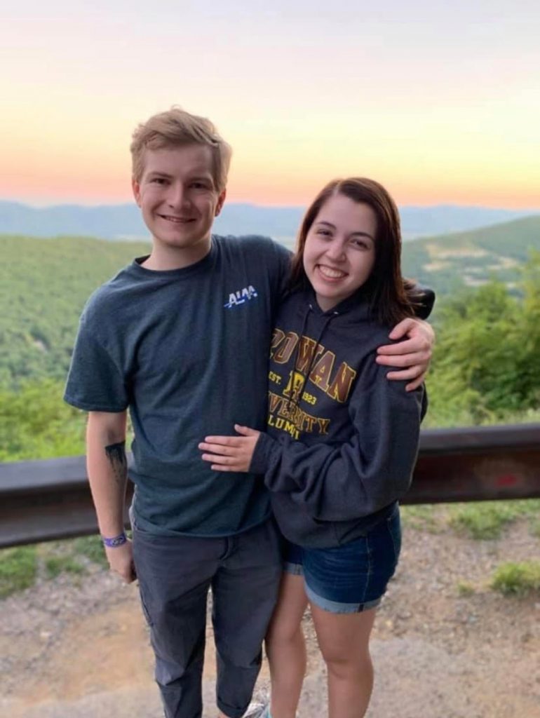 Bri and her fiancé pose in front of a sunset in their Rowan gear. 