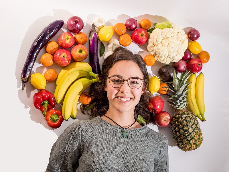 Student with fruits and vegetables.