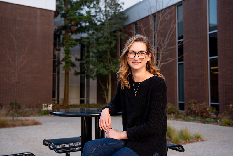 Amanda Marcks sits on a campus table and chair set.