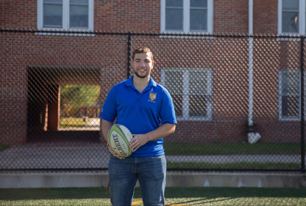 Chase poses on the intramural field with a rugby ball.