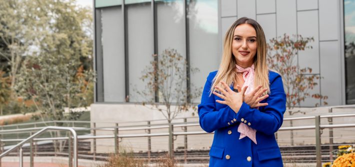Elena photographed outside campus wearing a blue blazer.