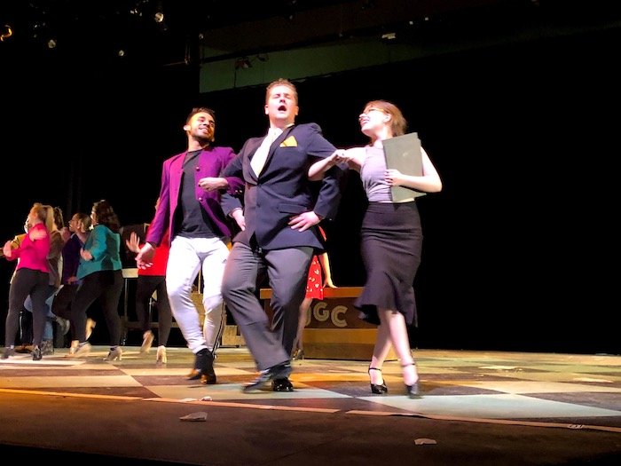 Erica performing in a show on stage with two other cast members.