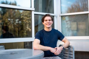 Liam sitting at a table outside of Engineering Hall. 