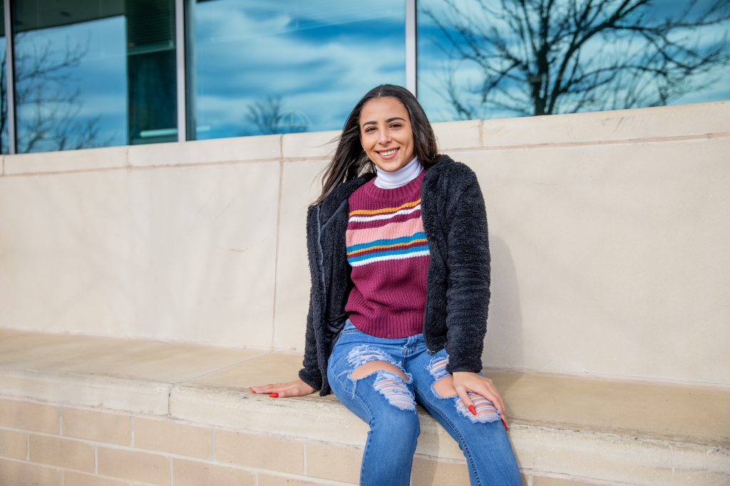 Mikayla sitting on the side outside of James Hall.