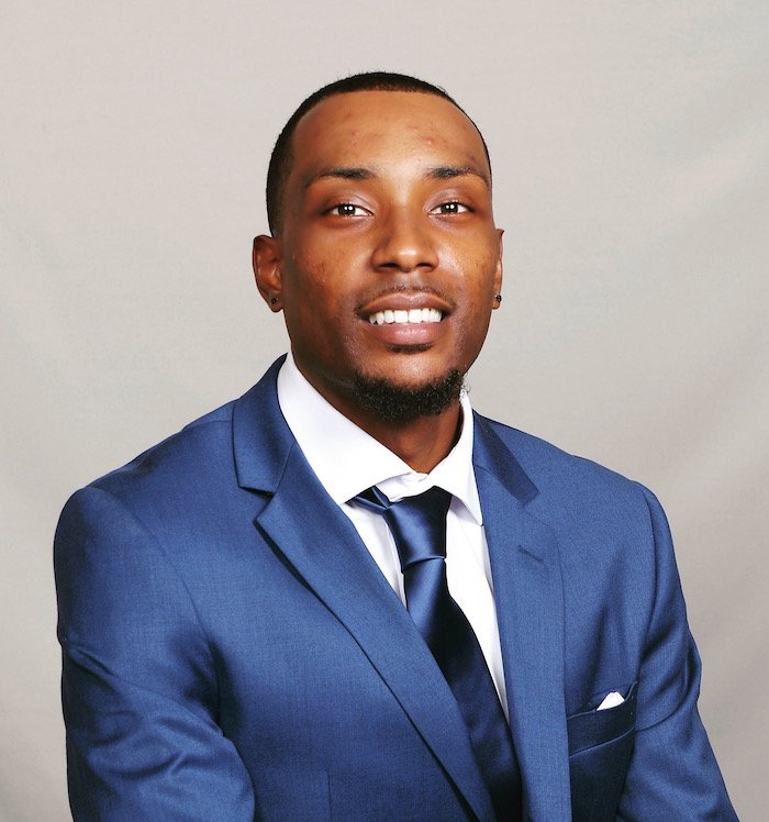 A portrait style photo of Amir wearing a suit.
