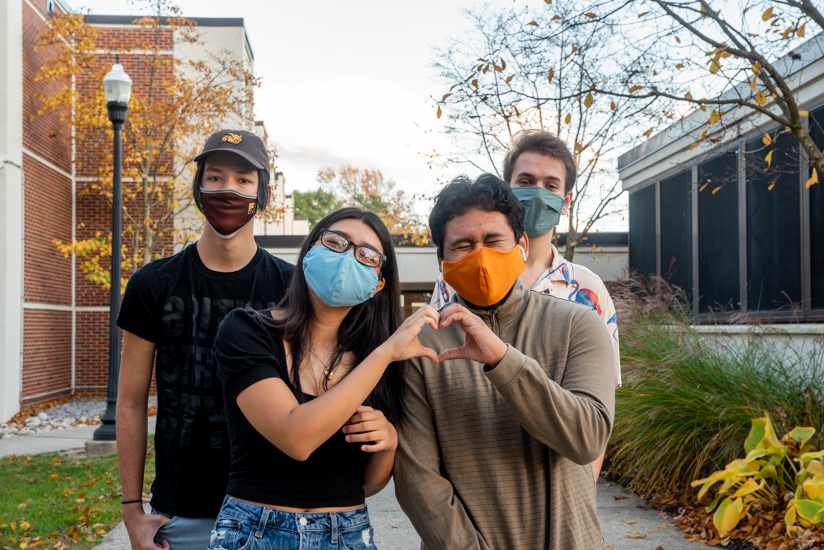 Group photo of four Evergreen residents, who are wearing masks. The two up front have their hands together to form the shape of a heart.