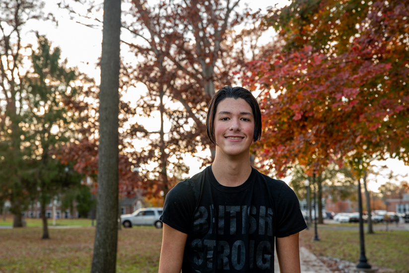 Christian standing outside with trees behind him.