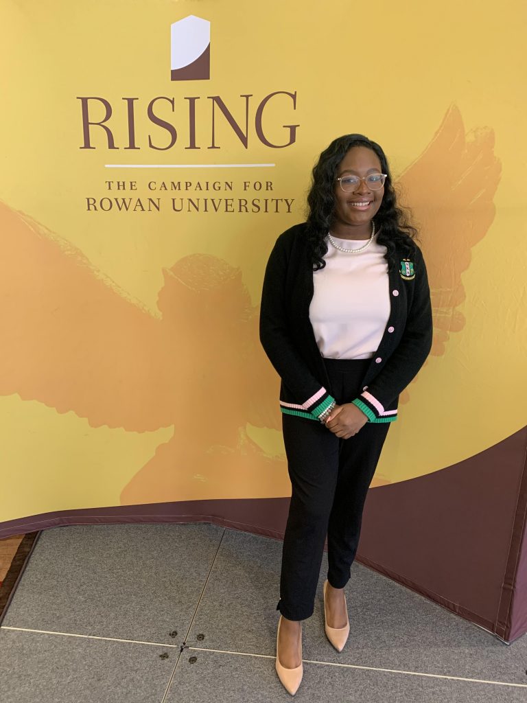 Arielle poses next to a Rowan campaign backdrop in her Alpha Kappa Alpha attire.