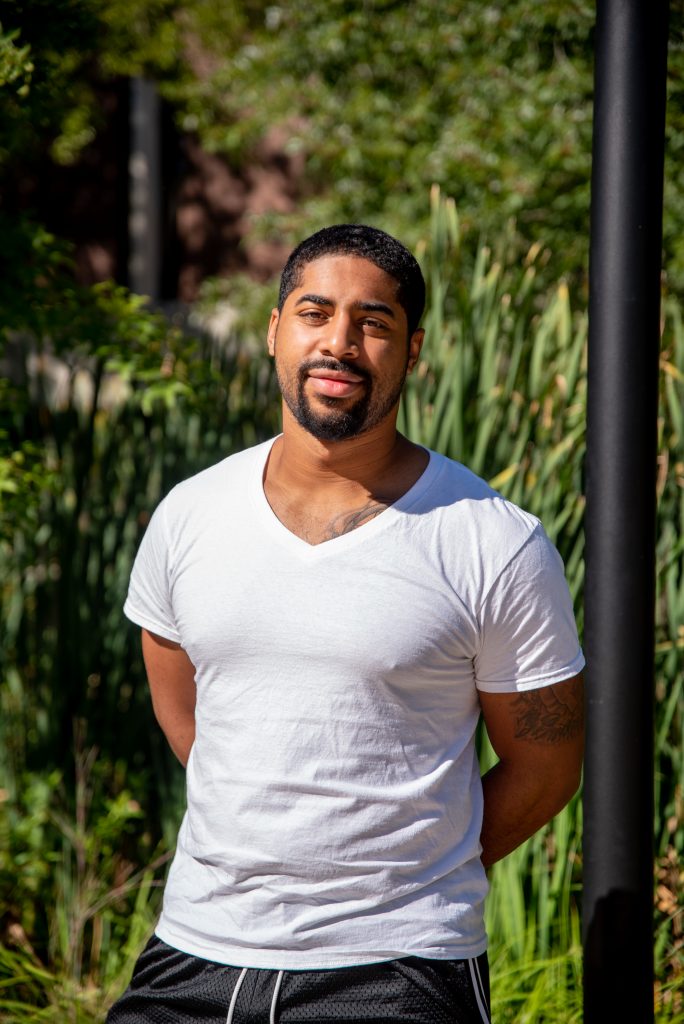 Trevor standing outside in a white shirt.