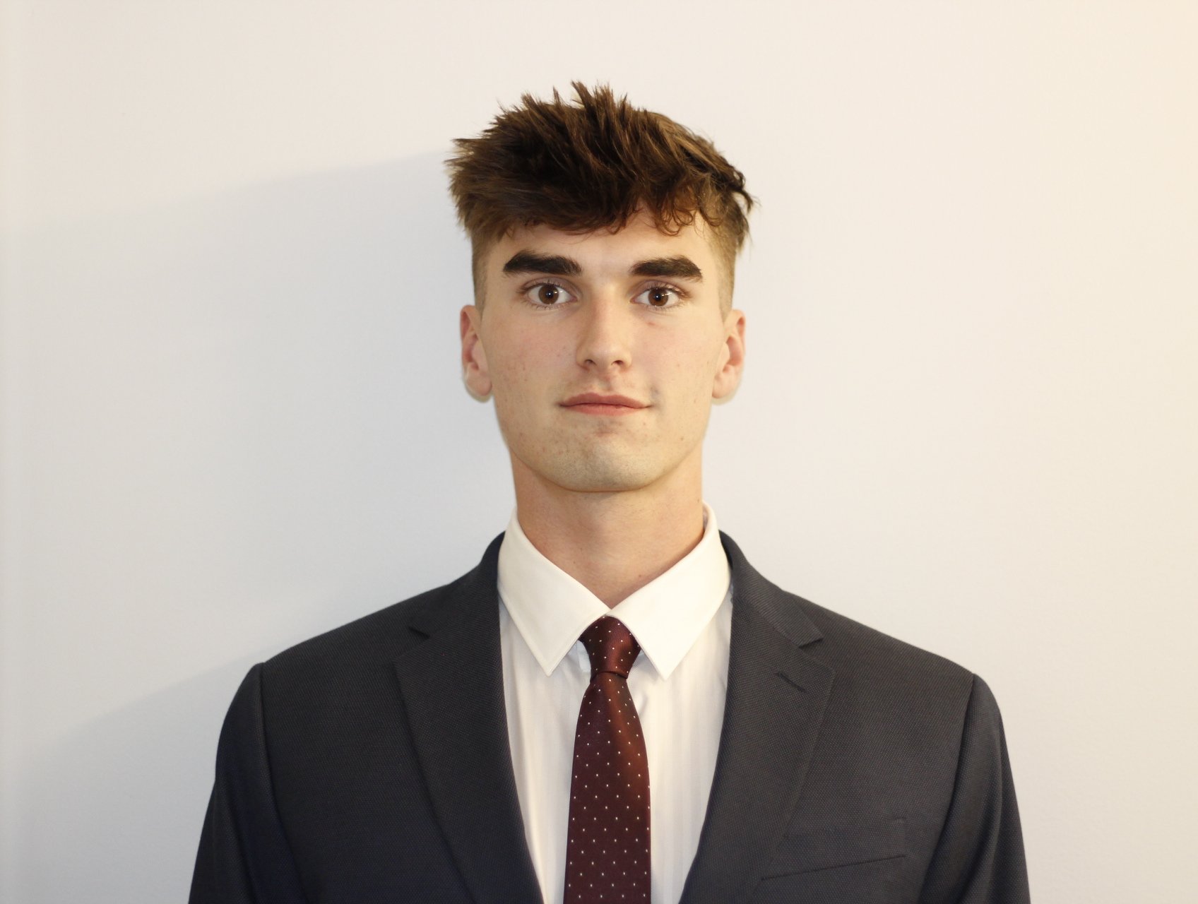 A portrait style photo of Ryan wearing a suit.