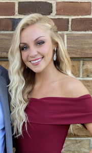 Amanda poses wearing a red dress.