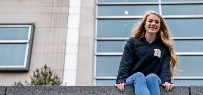 Ashleigh sits on a ledge outside of Engineering Hall.