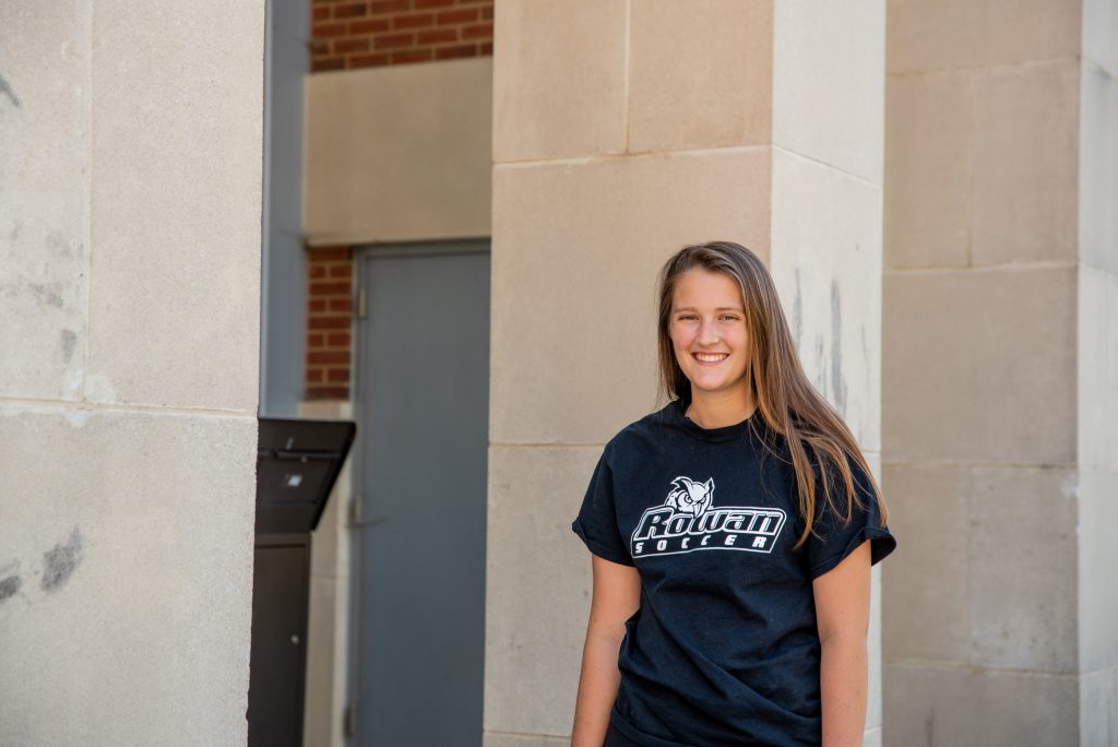 Catie poses by the Campbell Library wearing a Rowan soccer shirt.