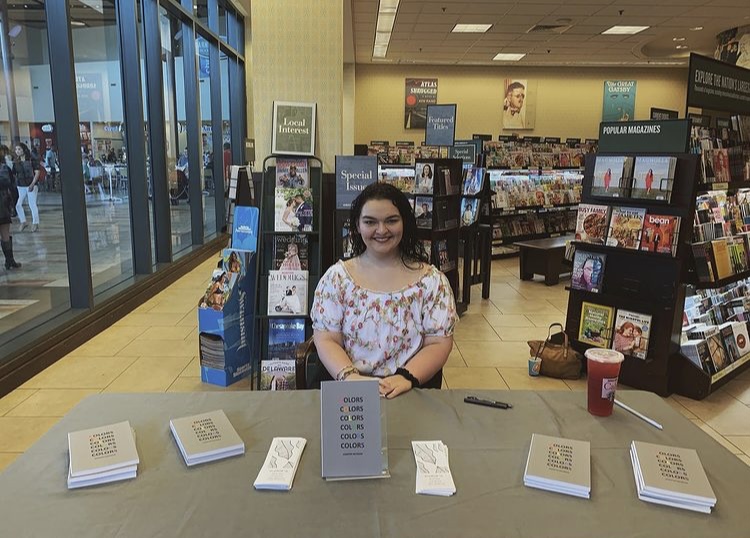 Jennifer poses at a book signing at a book store.