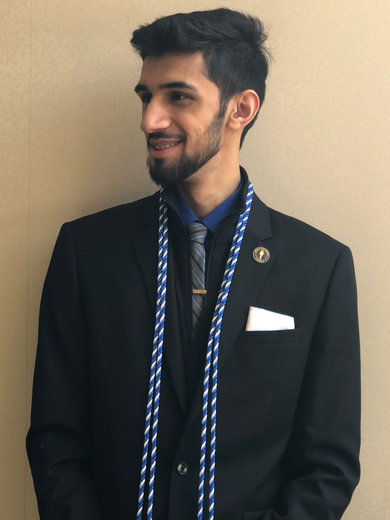 Fahed poses in a suit with his cords.