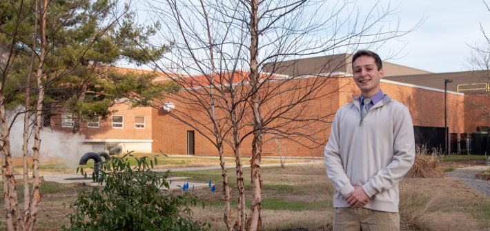 Steven poses outside by the Rec Center at Rowan.