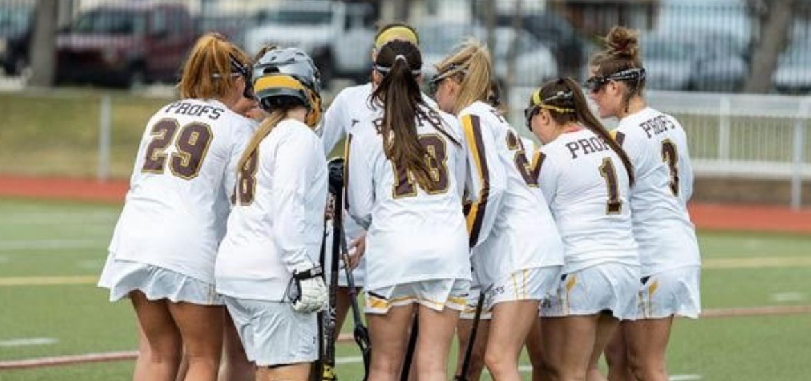 Rowan's Women's Lacrosse players huddle on the field.