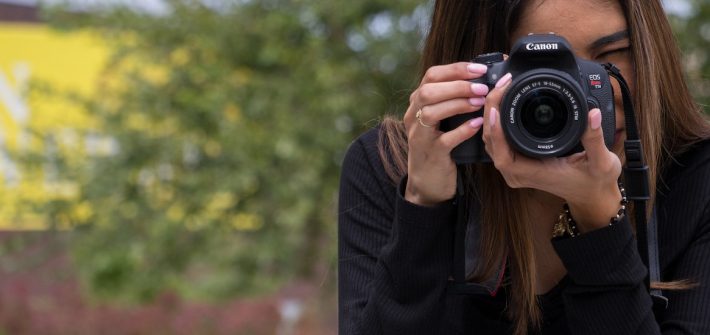 A Rowan student uses a DSLR camera to capture a moment.