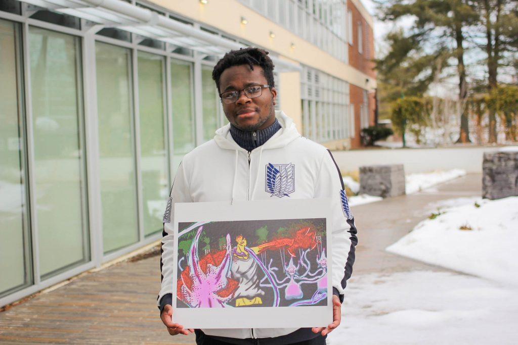 Ugonna holds up a piece of his art work.