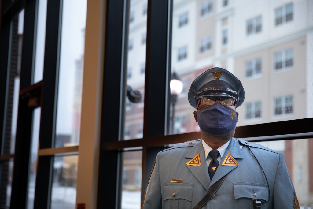Sgt. Barnes stands in front of a bank of windows. 
