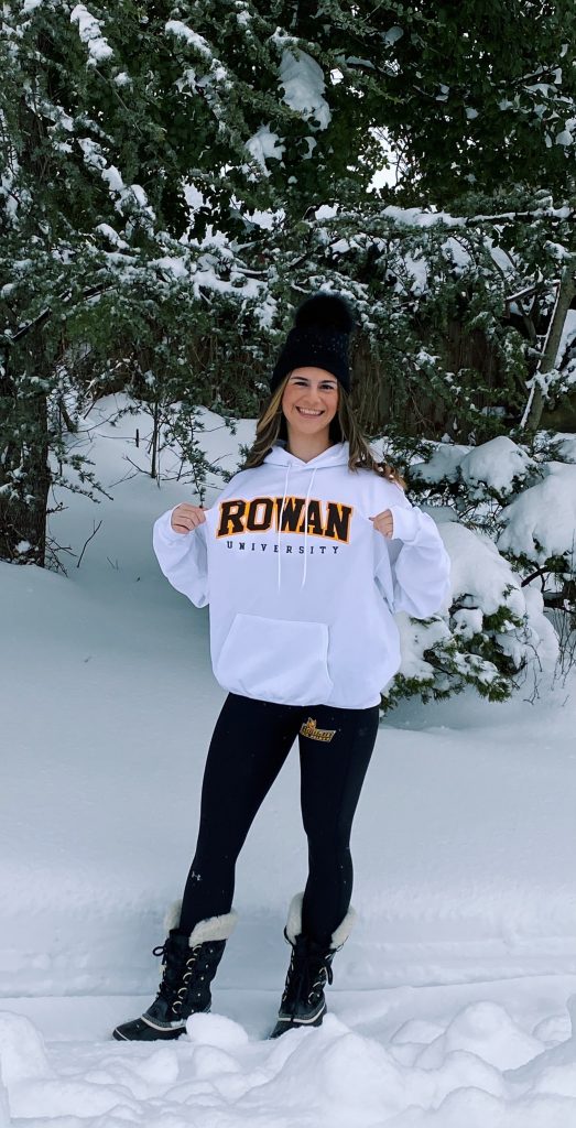 Isabel poses outdoors wearing a Rowan sweatshirt.