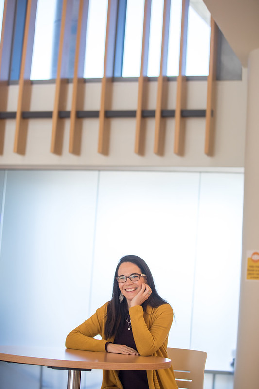 Dr. Susana Santos smiles by a railing in Business Hall.
