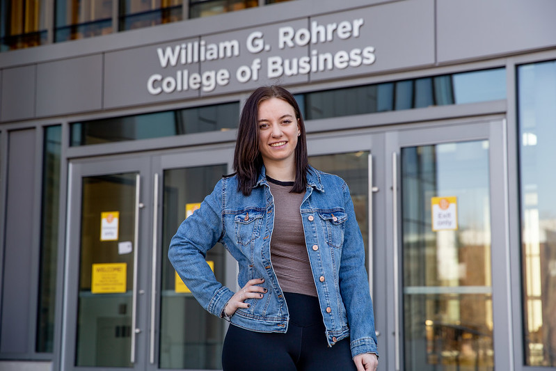 Lexi stands in front of the entrance to Business Hall.