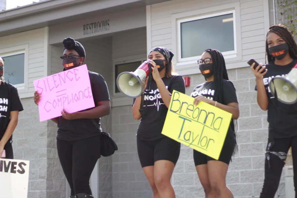 Bravo speaking into a horn at a protest.