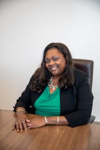 Lonniece sitting at a desk and smiling.