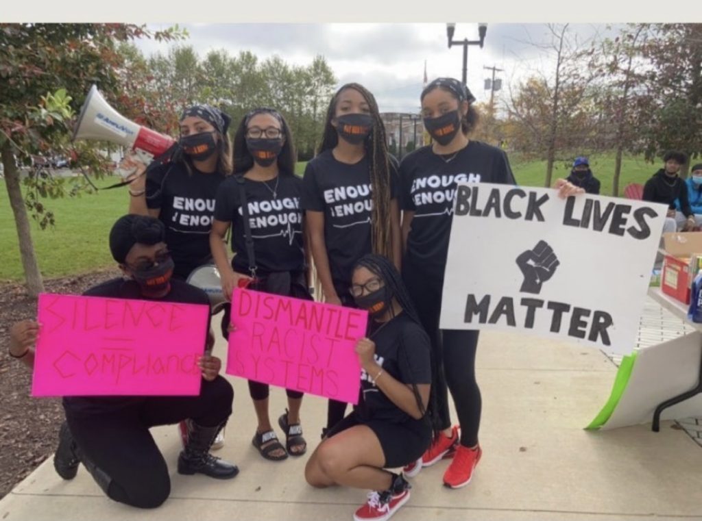 Alayna with a group wearing masks and holding Black Lives Matter signs.