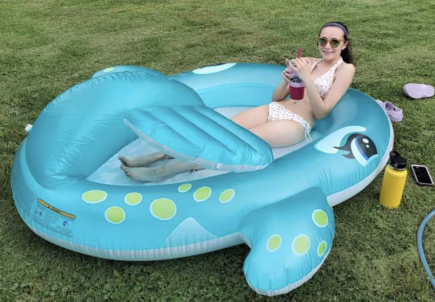 Alyssa sitting in an inflatable whale shaped pool.