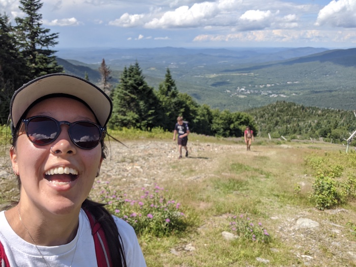 A picture of Hannah taking a selfie while on a hike.