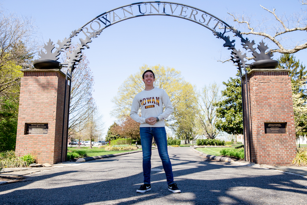 JT stands in front of the Rowan University archway near Bunce Hall.