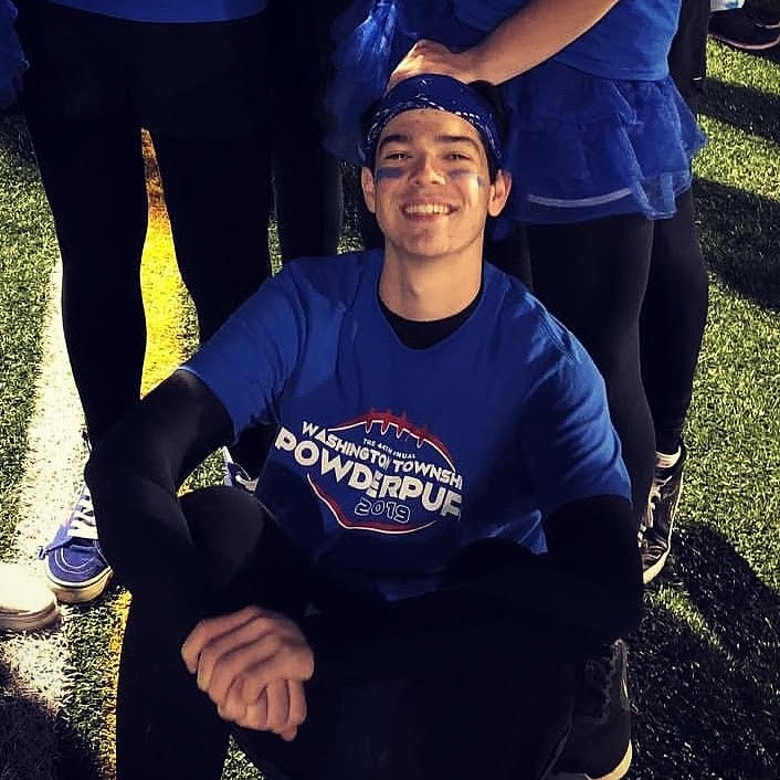 Will sitting on the floor of a football field.