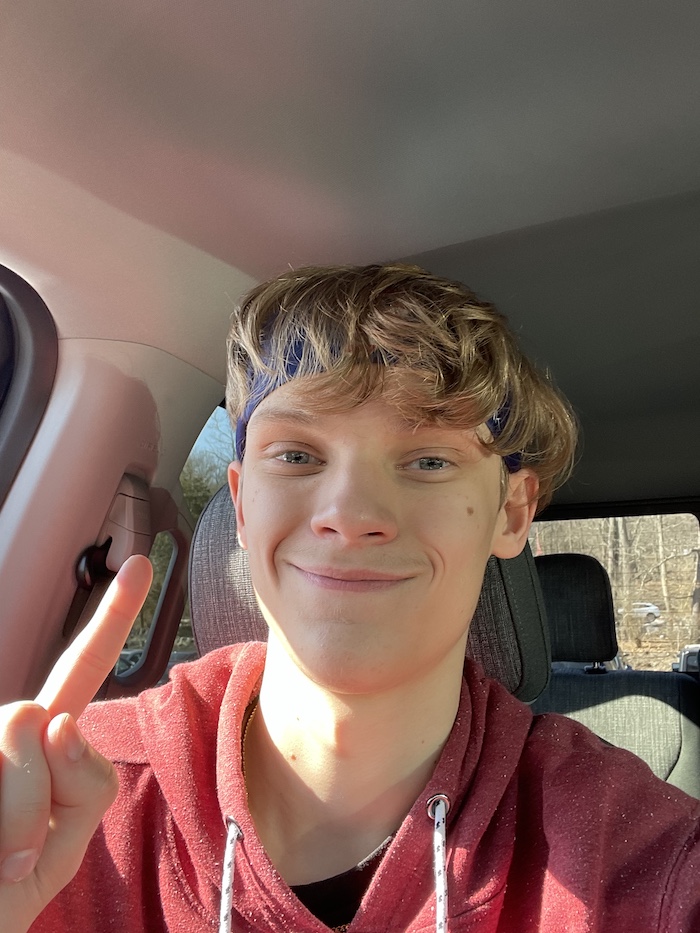 A selfie of Joseph smiling while in the car.