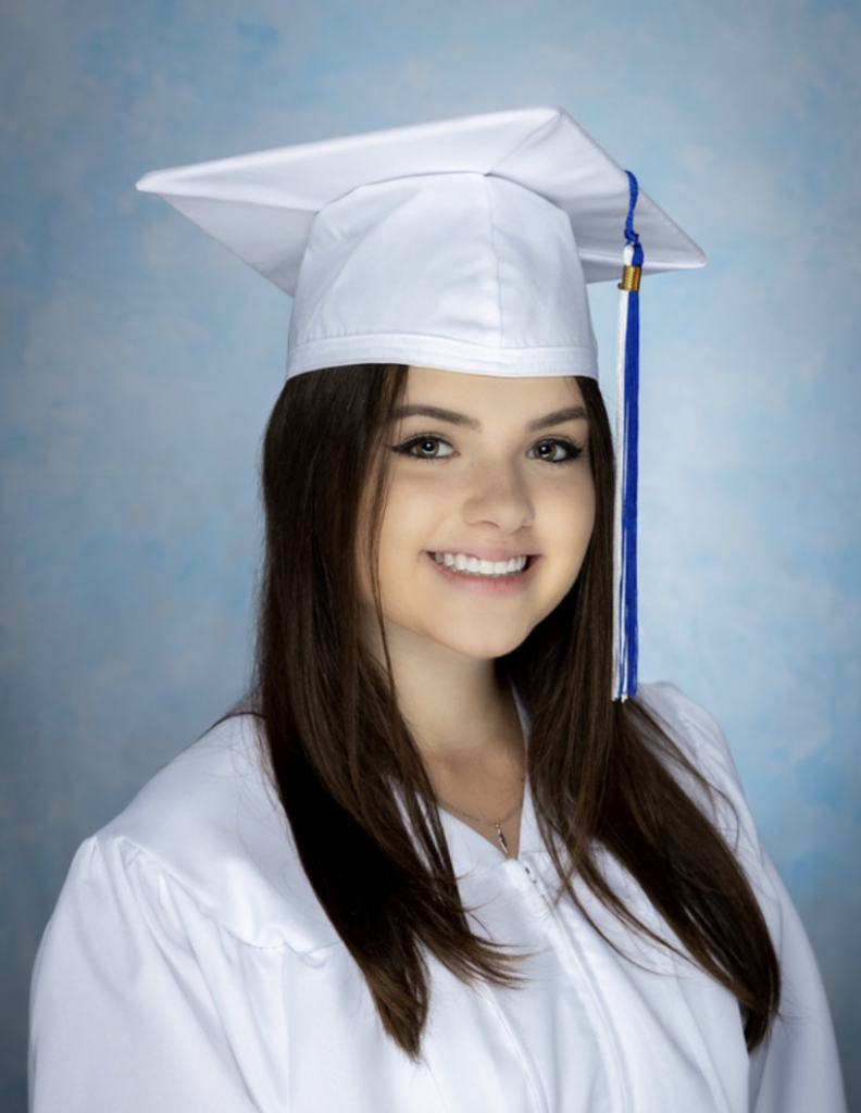 Anna's senior portrait in a white cap and gown.