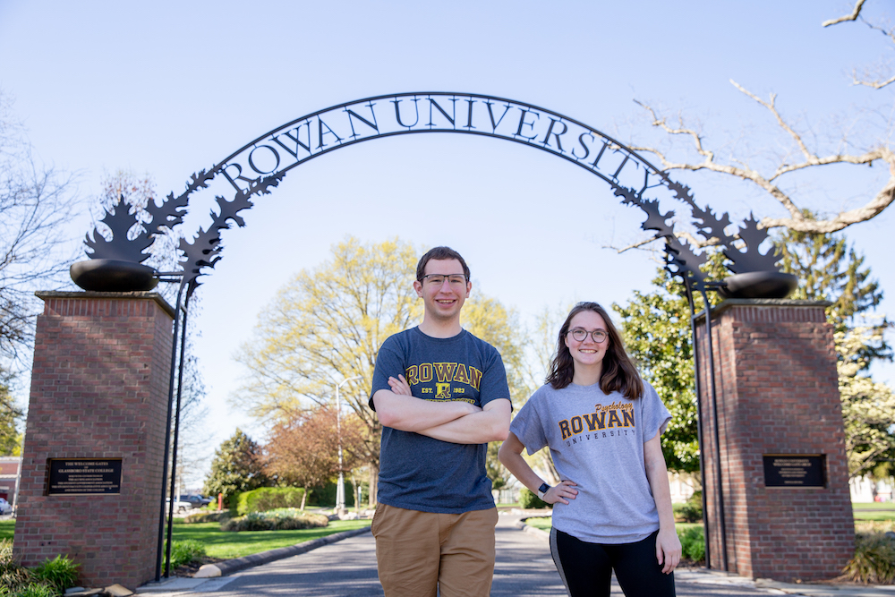 Leah and Kevin stand under the arch together.