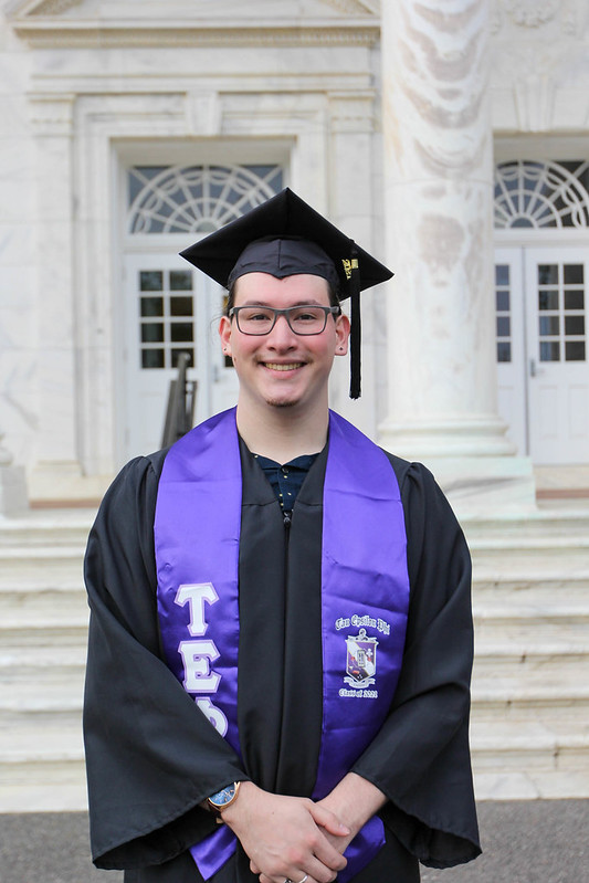 Zachery smiles in front of Bunce Hall.