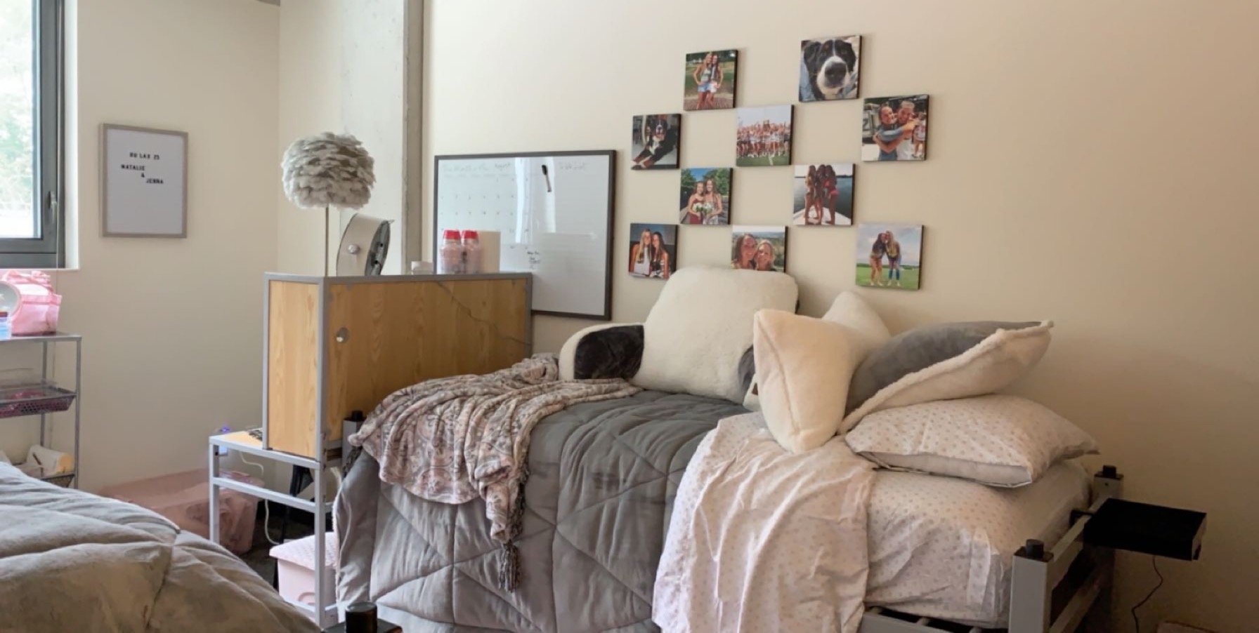 A light pink and gray decorated bedroom in Holly Pointe with photos on the wall. 