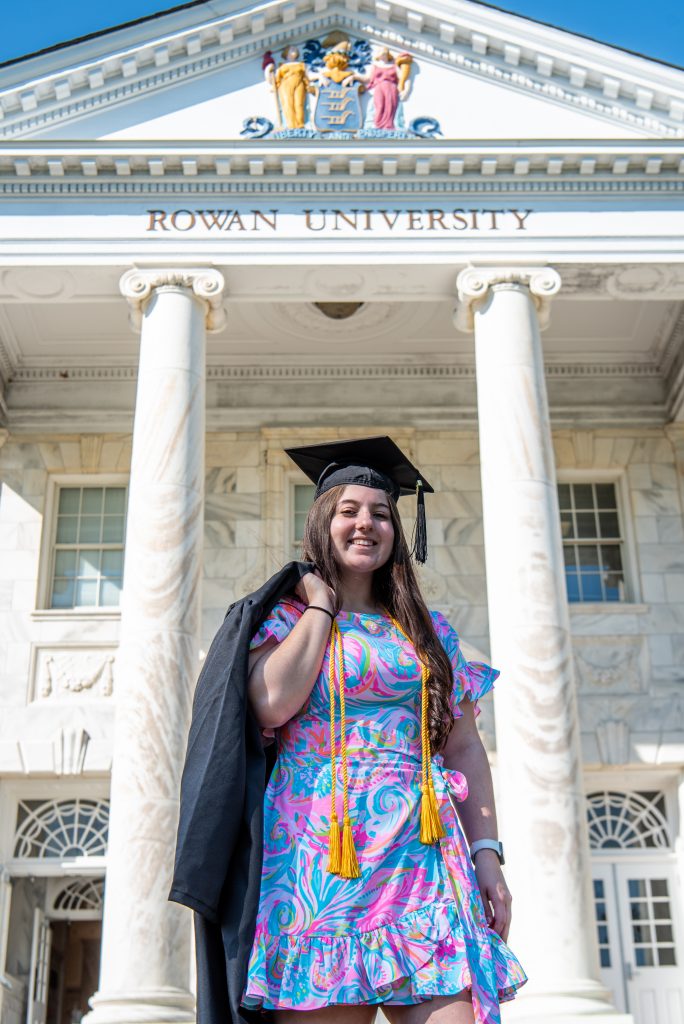 Kassidy poses with her cap and gown in front of Bunce Hall. 